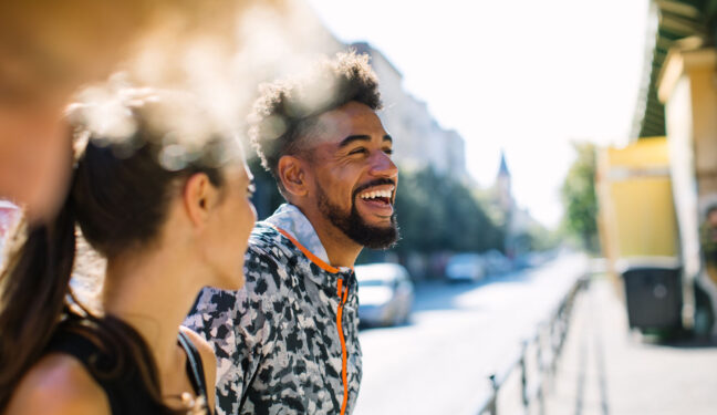 Young friends taking break after jogging in city