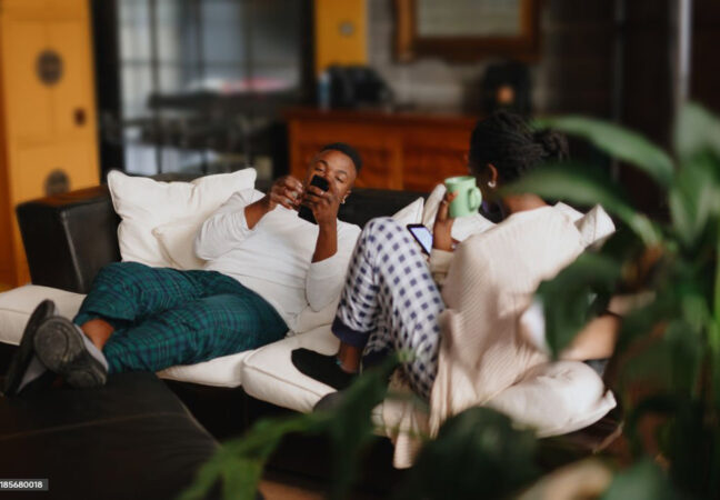 Roommates talking while resting on sofa at home